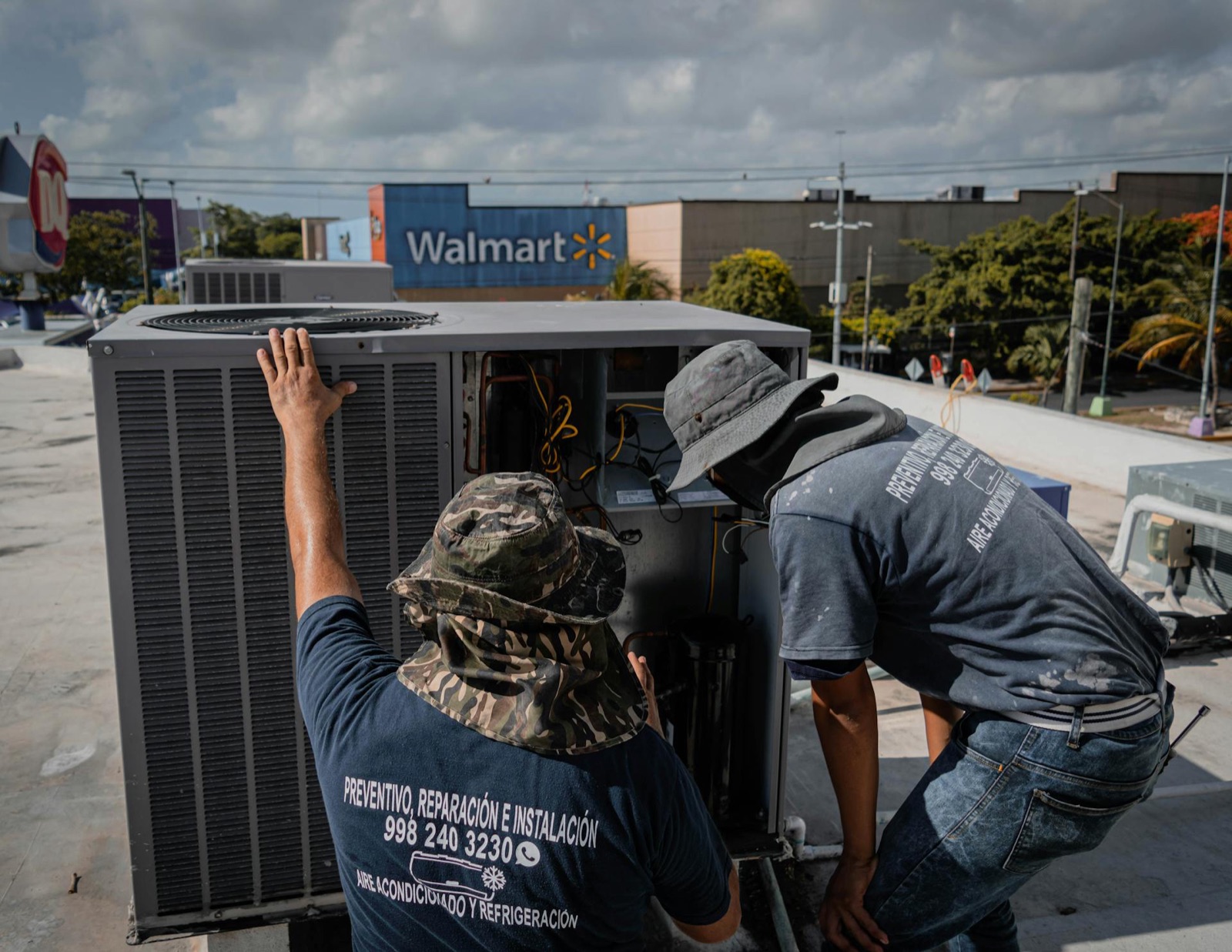Technicians servicing a commercial rooftop HVAC unit